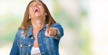 Casual denim ceket izole üzerinde giyen güzel orta yaş kadın arka plan sizin parmak el kamerasıyla göğüs üzerinde utanç ifadesi işaret eden gülme