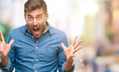 Yakışıklı delikanlı deli kutluyor ve silah ile başarı için heyecanlı çığlık kaldırdı ve açık gözleri hayret izole arka plan üzerinde. Kazanan kavramı