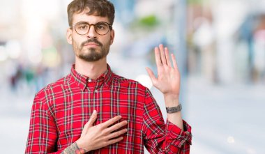 Yakışıklı delikanlı gözlüklü üzerinde arka izole göğüs ve bir sadakat sözü yemin yapma avuç, el ile küfür