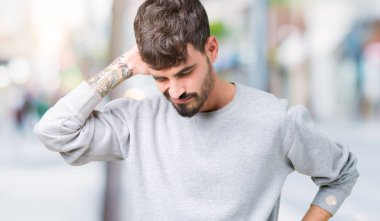 Genç yakışıklı adam giyen kazak izole üzerinde arka plan ile el, kas ağrısı boyun dokunmadan acı boyun ağrısı yaralanma,