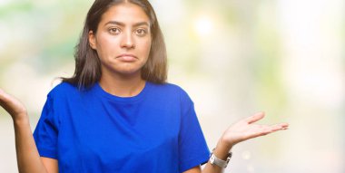 Genç güzel Arap kadın izole arka plan clueless ve şaşkın bir ifadeyle kollar ve eller kaldırdı. Şüphe kavramı.