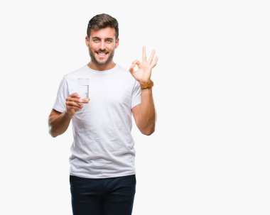 Yakışıklı delikanlı parmak, mükemmel sembolü ile ok işareti yapıyor izole arka plan üzerinde bardak su içme