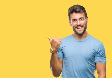 Yakışıklı delikanlı arıyor ve başparmak yanında yukarıyı mutlu yüz ile gülümseyen izole arka plan üzerinde.