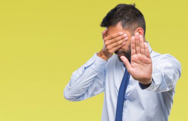 Yetişkin İspanyol iş adam elleriyle gözlerini kapsayan izole arka plan üzerinde ve stop jest ile acı ve korku ifadesi. Utandım ve negatif kavramı.