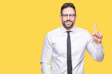 Ve parmak gülümseyen süre bir numara ile kendinden emin ve mutlu yukarıyı gösteren izole arka plan üzerinde gözlük takan genç yakışıklı iş adamı.