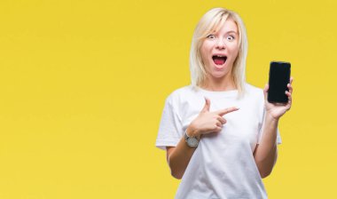 Genç güzel sarışın kadın gösteren ekran smartphone üzerinde izole arka el ve parmak ile işaret çok mutlu