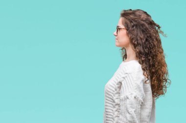 Güzel esmer kıvırcık saç üzerinde kış kazak giyen genç kız tarafına, seyir arka plan izole dinlenmek doğal yüz emin gülümseme ile pozuyla profili.