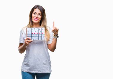 Genç güzel kadın holding adet izole arka bir fikirle sürpriz üzerinde takvim veya gülen yüz, bir numara ile işaret parmağı soru