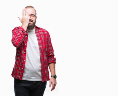 Üzerinde gözlük takan Genç beyaz hipster adam arka plan kapsayan bir göz yüz ve sürpriz duygu kendinden emin gülümseme ile el ile izole.