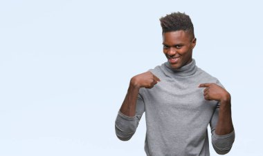 Yüzünde gülümseme ile kendinden emin görünüyorsun, kendini gururlu ve mutlu parmakları ile işaret izole arka plan üzerinde genç Afro-Amerikan adam.