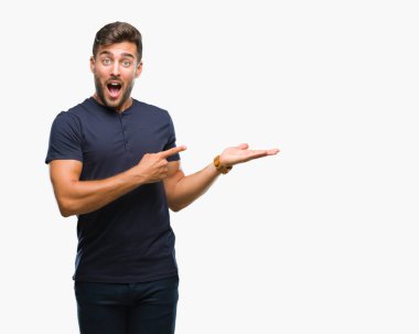 Yakışıklı delikanlı üzerinden hayran ve el ile sunulması ve parmak ile işaret ederken kameraya gülümseyen izole arka plan.