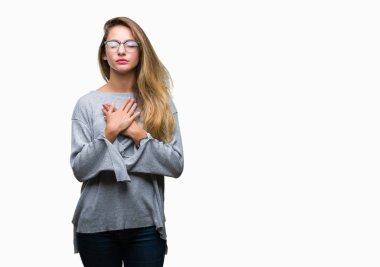 Genç güzel sarışın kadın ile gülümseyen izole arka plan üzerinde gözlük takan kapalı gözler ve yüzünde minnettar jest ile göğüs üzerinde eller. Sağlık kavramı.