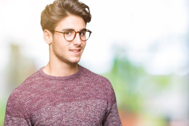 Uzak tarafına yüzünde, doğal ifade gülümseme ile seyir izole arka plan üzerinde gözlük takan yakışıklı delikanlı. Kendine güvenen gülüyor.