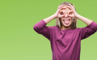 Genç güzel kız yüzünden izole arka plan, dilini parmaklarının arasından baktığını yapışmasını dürbün gibi ok jest yapıyor. Deli ifade.