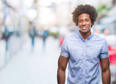 Yüzünde mutlu ve güzel bir gülümseme ile izole arka plan üzerinde Afro Amerikalı adam. Şanslı kişi.