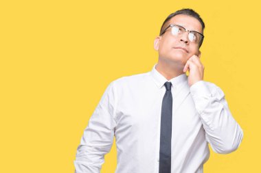 Orta yaş bussines Arap adam çene düşünme hakkında soru, dalgın ifade üzerine el ile izole arka plan üzerinde gözlük takıyorum. Düşünceli yüzüyle gülümsüyor. Şüphe kavramı.