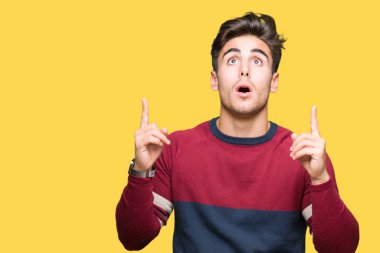 Yakışıklı delikanlı izole arka plan üzerinden hayran ve yukarıya bakıp parmakları ile işaret şaşırttı ve silah kaldırdı.