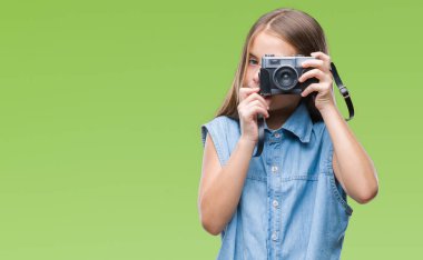 Vintage fotoğraf makinesi ile acımak yüz ciddi düşünme emin bir ifade izole arka plan üzerinde kullanarak fotoğrafları alarak genç güzel kız