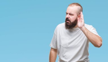 Bir işitme söylenti ya da dedikodu için dinleme kulak üzerinde el ile gülümseyen izole arka plan üzerinde rahat t-shirt giyen genç beyaz hipster adam. Sağırlık kavramı.