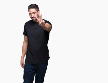 Arka planda kalan yakışıklı genç adam kameraya bakıp zafer işareti yaparken gülümsüyor. İki numara..