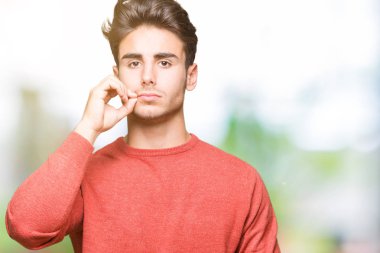 Yakışıklı delikanlı izole arka plan ağız ve dudaklar üzerinde parmak ile ZIP olarak kapatın. Gizli ve sessiz, tabu söz