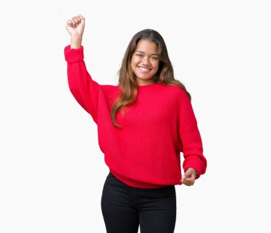 İzole arka plan dans mutlu ve neşeli, hareketli rahat ve kendinden emin müzik gülümseyen üzerinde kırmızı kış kazak giyen genç güzel esmer kadın