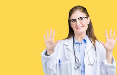 Gösterilen ve parmakları ile işaret izole arka plan üzerinde tıbbi ceket giyen orta yaş olgun doktor kadın kendinden emin ve mutlu gülümseyerek süre on numara.