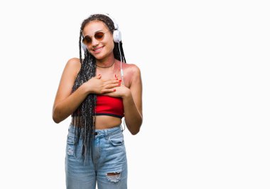 Genç örgülü saç Afrika kökenli Amerikalı Doğum işareti üzerinde gülümseyen izole arka plan ile kulaklıklar giyen kapalı gözler ve yüzünde minnettar jest ile göğüs üzerinde eller. Sağlık kavramı.