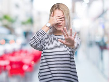 Genç Sarışın kadın izole elleriyle gözlerini kapsayan arka plan ve stop jest ile acı ve korku ifadesi. Utandım ve negatif kavramı.