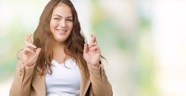 Güzel izole arka plan üzerinde kış ceket giyen boyutu genç kadın artı geçiş parmakları umut ve gözler gülümseyen kapalı. Şans ve batıl kavramı.