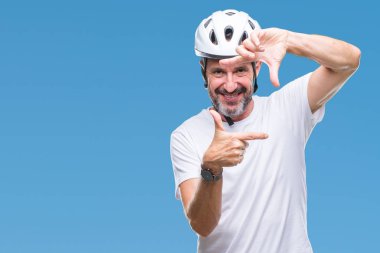 Bisiklet Emanet helment giyen orta yaş üst düzey ağarmış bisikletçi adam arka plan elle yapma çerçeve ve parmakları ile mutlu yüz gülümseyen izole. Yaratıcılık ve Fotoğrafçılık kavramı.
