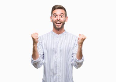 İzole arka plan kutlama üzerinde genç yakışıklı adam şaşırttı ve başarı için kaldırdı kollarını açarak hayret ve gözleri açık. Kazanan kavramı.