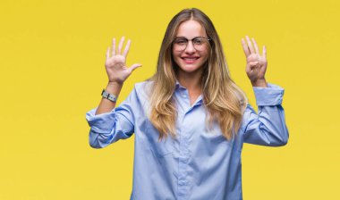 Genç güzel sarışın iş kadın gözlük gösterilen ve parmakları ile işaret izole arka plan üzerinde dokuz kendinden emin ve mutlu gülümseyerek iken numara.