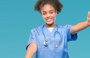 Genç afro Amerikalı doktor kadın sarılmak için kollarını açarak gülümseyerek kameraya bakarak izole arka plan yüzünden. Neşeli ifade kucaklayan mutluluk.
