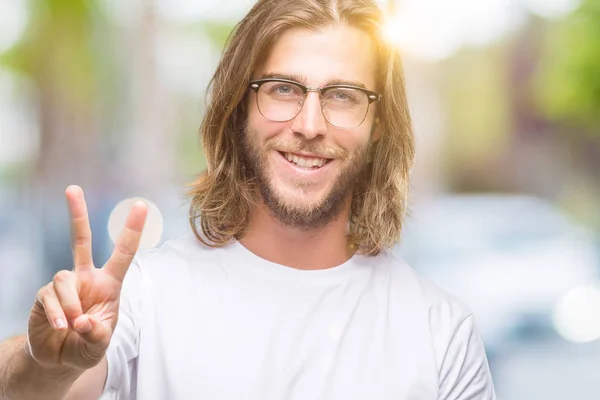 Mladý Pohledný Muž Dlouhými Vlasy Nosí Brýle Izolované Pozadí Usmívající — Stock fotografie