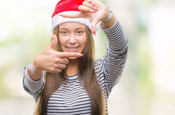 若い美しい白人女性の笑顔と幸せそうな顔で指手作りフレーム分離の背景にクリスマス帽子をかぶっています 創造性と写真のコンセプト — ストック写真