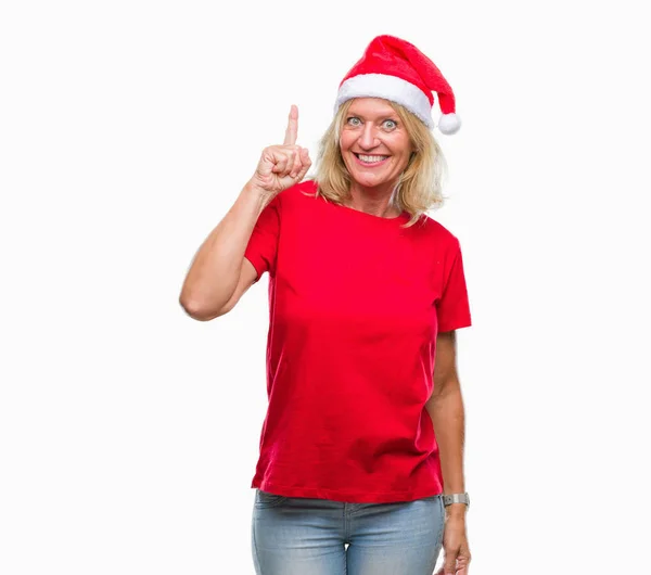 中年金发碧眼的女人戴着圣诞帽在孤立的背景指向手指与成功的想法 离开和快乐 — 图库照片