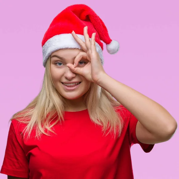 若い白人女性手の笑顔 幸せそうな顔で指を通して見る目で のジェスチャーを行う分離の背景にクリスマスの帽子をかぶって — ストック写真