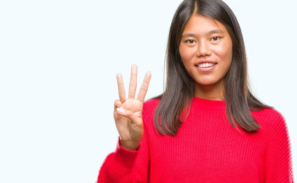 若いアジア女性着て冬セーター分離背景表示と指で上向きに番号自信を持って 幸せな笑みを浮かべている間 — ストック写真