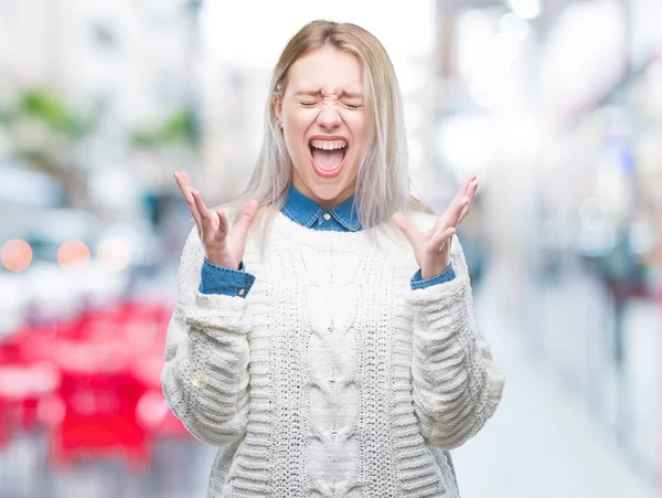 年轻的金发女人穿着冬季毛衣在孤立的背景下庆祝疯狂和疯狂的成功与手臂举起和闭上眼睛尖叫兴奋 赢家理念 — 图库照片