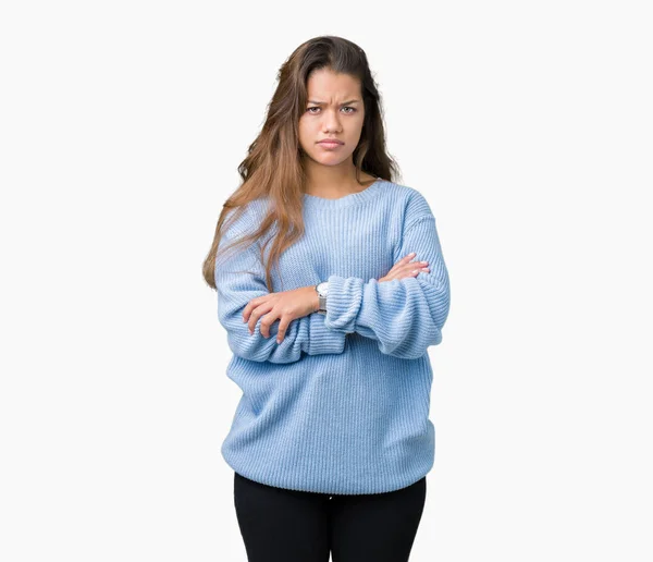 年轻美丽的黑发女人穿着蓝色的冬季毛衣在孤立的背景怀疑和紧张 不赞成表情的脸与交叉的手臂 消极的人 — 图库照片
