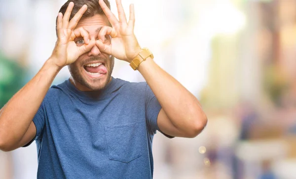 Homem Bonito Jovem Sobre Fundo Isolado Fazendo Gesto Como Binóculos — Fotografia de Stock