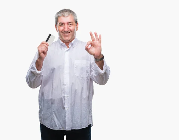 Bonito Homem Idoso Segurando Cartão Crédito Sobre Fundo Isolado Fazendo — Fotografia de Stock