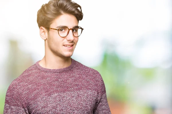 Uzak tarafına yüzünde, doğal ifade gülümseme ile seyir izole arka plan üzerinde gözlük takan yakışıklı delikanlı. Kendine güvenen gülüyor.