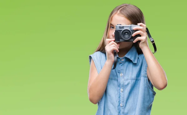年轻美丽的女孩拍照使用老式相机在孤立的背景与自信的表情在聪明的脸思考严重 — 图库照片