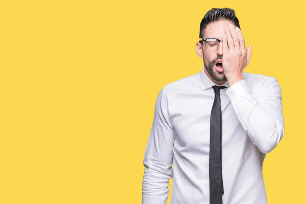 Young handsome business man wearing glasses over isolated background Yawning tired covering half face, eye and mouth with hand. Face hurts in pain.