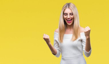 Genç güzel sarışın kadın üzerinde gözlük gülümseyen ve başarı için çığlık arka plan çok mutlu ve heyecanlı kaldırdı, silah ile kazanan jest yapıyor izole. Kutlama kavramı.