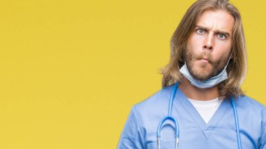 Genç yakışıklı izole arka plan yapma balık yüzüne dudaklı, çılgın ve komik bir jest uzun saçlı adam doktor. Komik ifade.