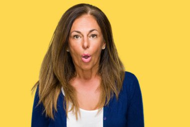 Güzel orta yaş rahat yetişkin kadın izole arka plan korkuyor ve sürpriz ifade ile şok yüzünden korku ve yüz heyecanlı.