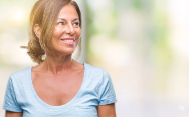 İzole arka plan uzak tarafına gülümseme ile yüzünde, doğal ifade seyir üzerinde orta yaş İspanyol kadın kıdemli. Kendine güvenen gülüyor.